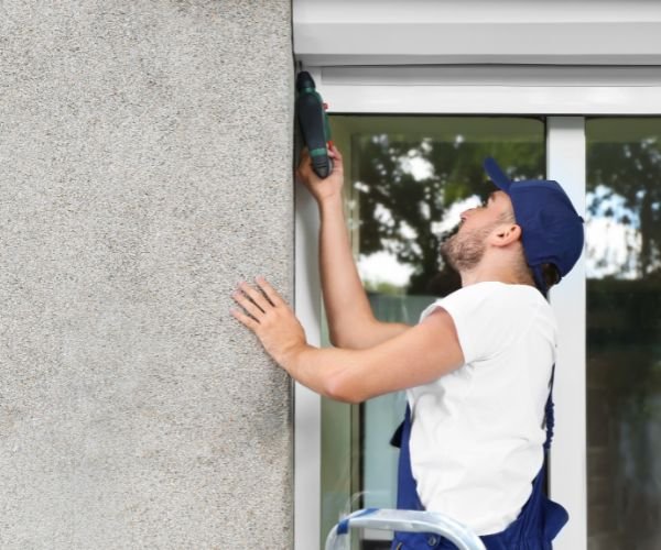 Monteur baut Rolladen am Fenster ein – Rolladen Montage